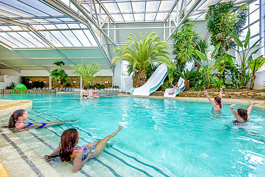 Piscine couverte avec toboggans et végétation tropicale au camping CAPFUN Cenic à PENESTIN (56). Piscine couverte avec toboggans et végétation tropicale au camping CAPFUN Cenic à PENESTIN (56).